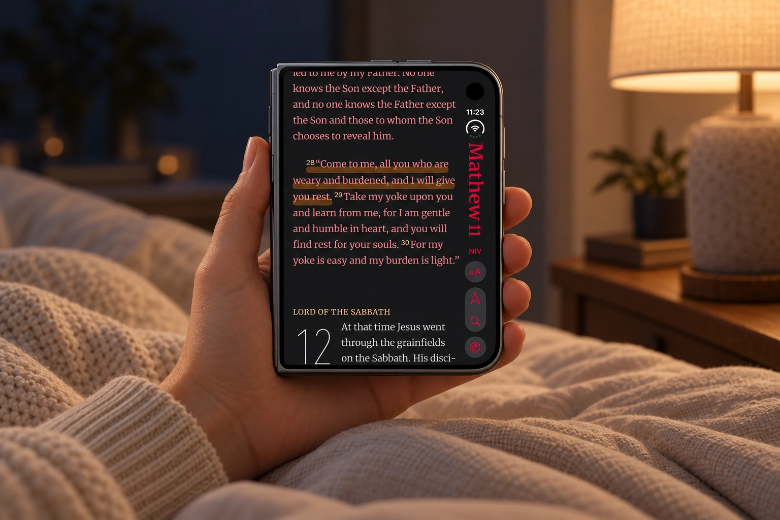 Before sleep, reading Matthew 11 on the folded iPhone Duo outer display in a softly lit bedroom